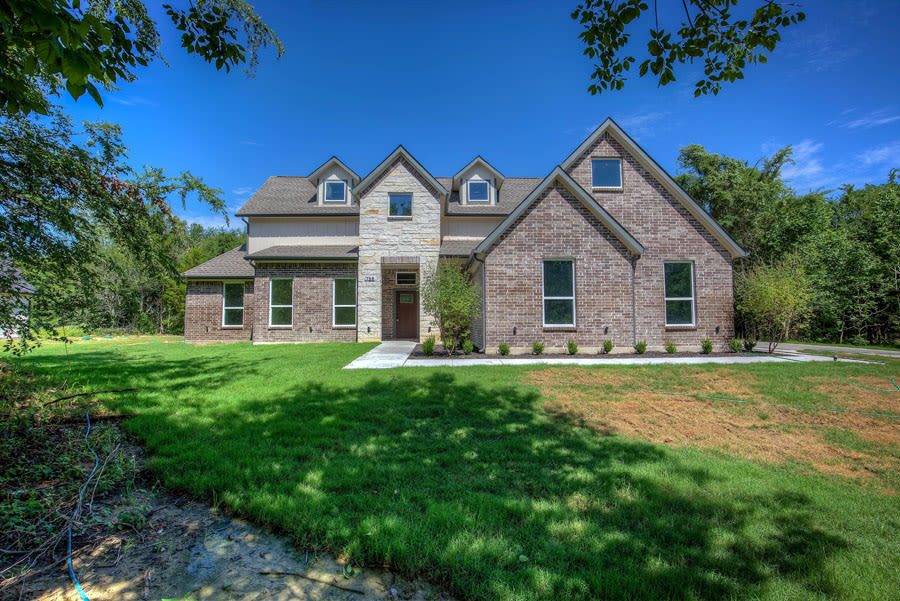 Custom two-story brick and stone home built by Mcilrath Properties in Terrell, Texas